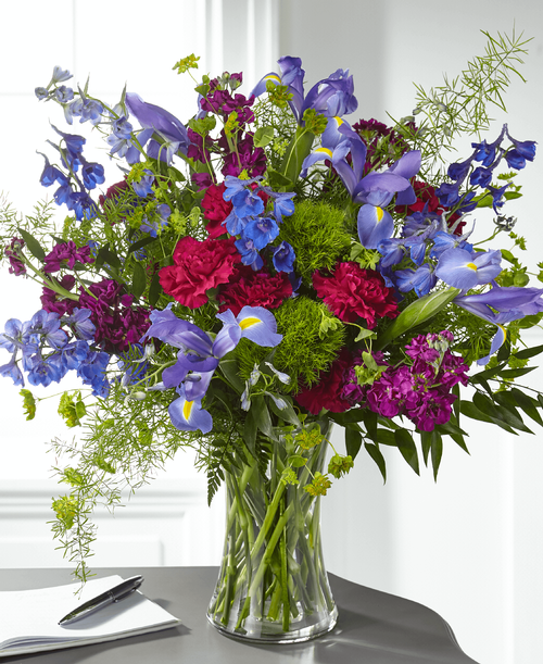 Elegantly designed with a modern mix of wildflower blooms, our Giving Grace Bouquet expressed an enlightening message of your sympathy. This charming arrangement is crafted with iris, stock and delphinium t convey your condolences. While this bouquet is perfectly beautiful in size, it is best suited for a small table, or within a home or residence.
Good bouquet is approximately 18 inchH x 19 inchW 
Better bouquet is approximately 20 inchH x 20 inchW 
Best bouquet is approximately 21 inchH x 21 inchW