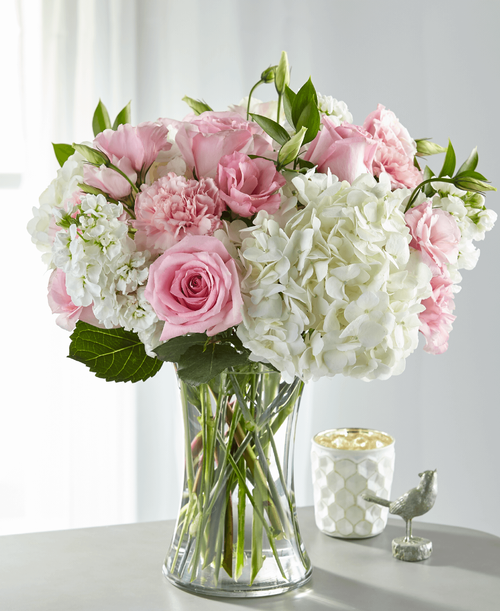 Share comfort, love and solace with a bouquet designed with blushing pink and pure white blooms. An array of hydrangea, stock, roses and lisianthus come together in a glass vase t create our Guiding Grace Bouquet. While this arrangement is simply sweet in size, it is best place on a small table, or within the home of your loved ones.
Good bouquet is approximately 16 inchH x 14 inchW
Better bouquet is approximately 17 inchH x 15 inchW 
Best bouquet is approximately 18 inchH x 16 inchW 