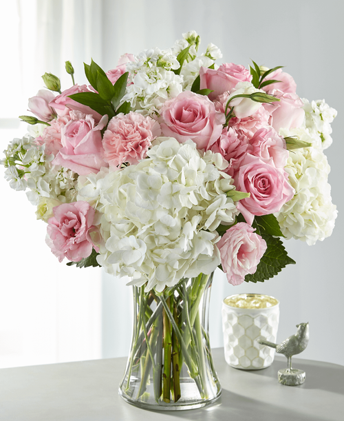 Share comfort, love and solace with a bouquet designed with blushing pink and pure white blooms. An array of hydrangea, stock, roses and lisianthus come together in a glass vase t create our Guiding Grace Bouquet. While this arrangement is simply sweet in size, it is best place on a small table, or within the home of your loved ones.
Good bouquet is approximately 16 inchH x 14 inchW
Better bouquet is approximately 17 inchH x 15 inchW 
Best bouquet is approximately 18 inchH x 16 inchW 
